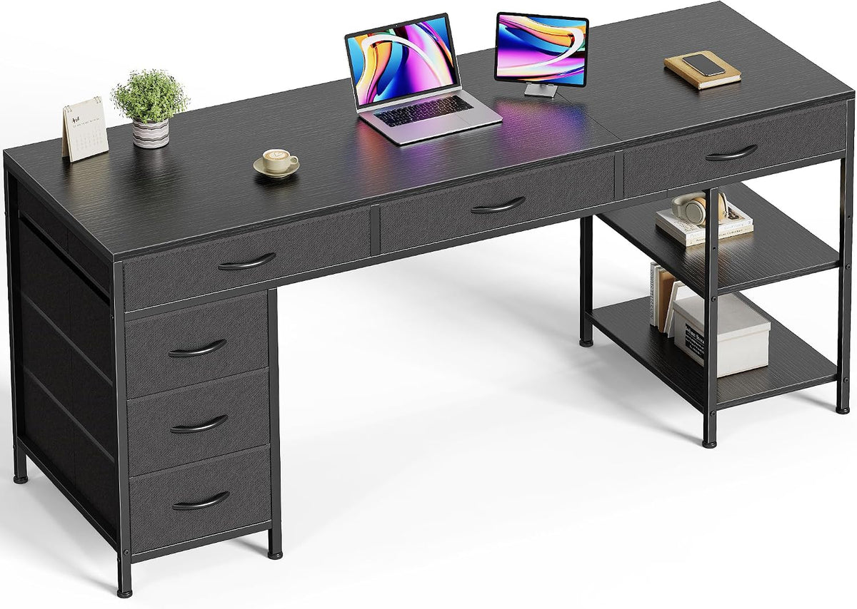 High-angle view showing a deep matte black desktop surface with three shallow top drawers and staged laptop.