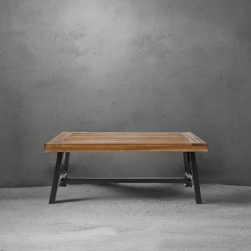 Acacia slat-top coffee table studio shot centered against a textured gray backdrop showing overall silhouette