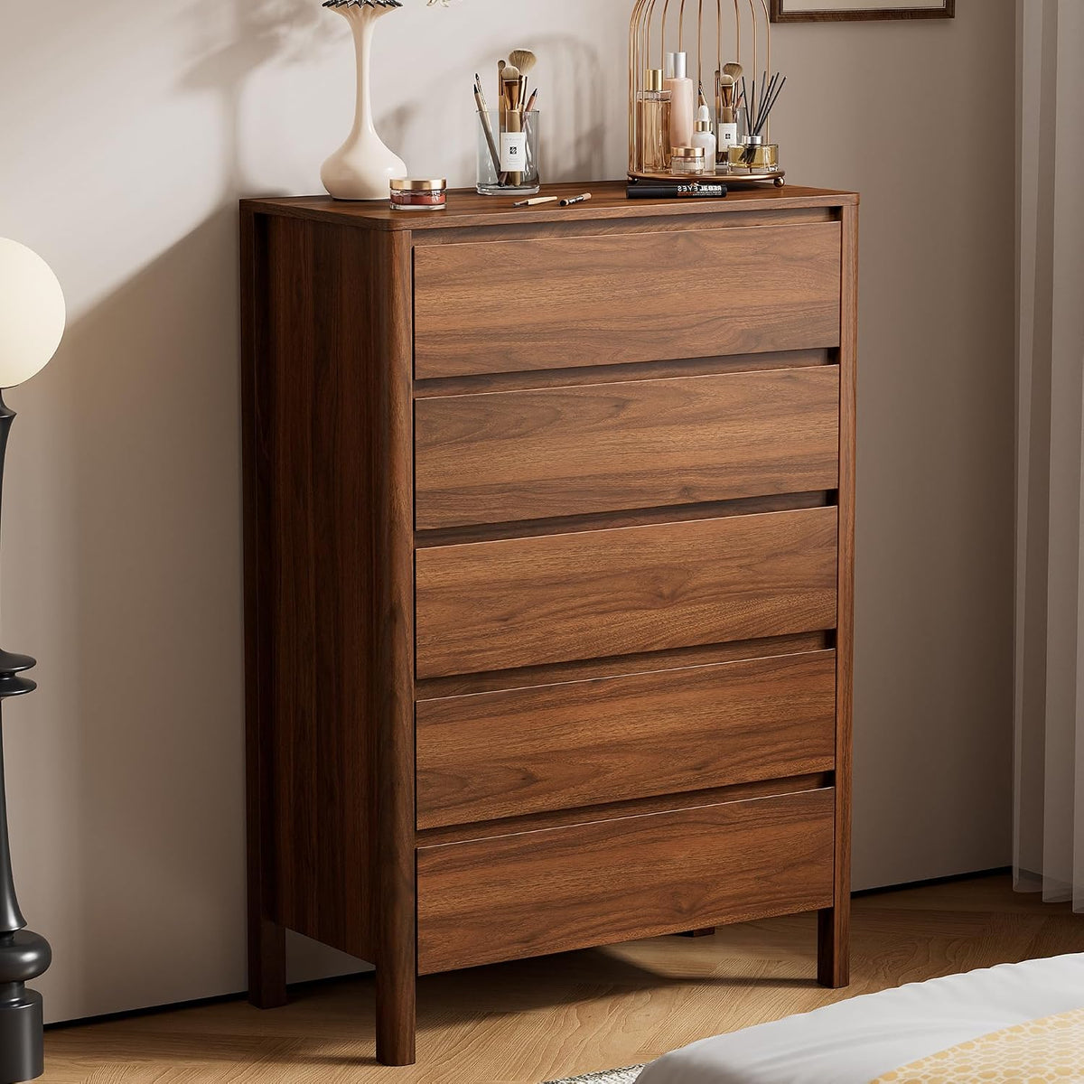 Staged front view of the walnut dresser with decor on top, showing hidden handles and mid-century clean lines