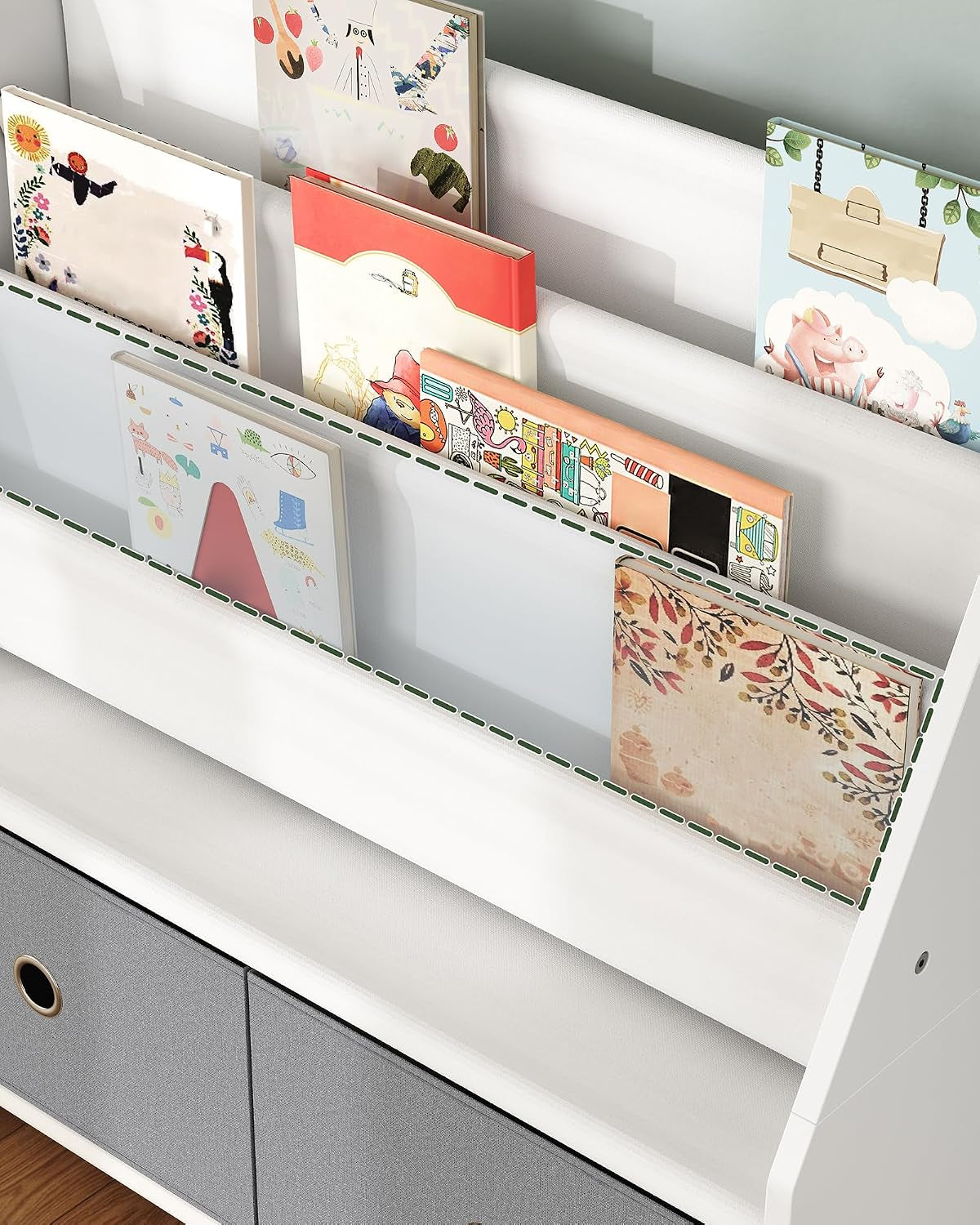 Close top view of three slanted fabric book pockets holding colorful children's books.