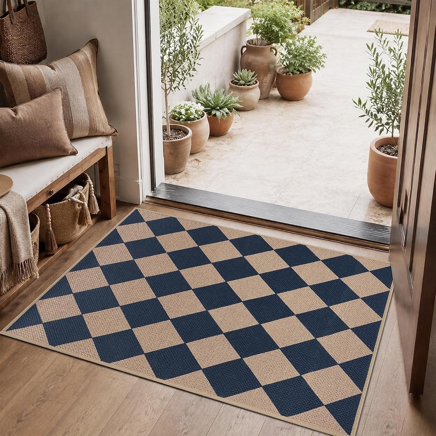 Square navy-and-beige checker rug laid inside a doorway with potted plants outside.