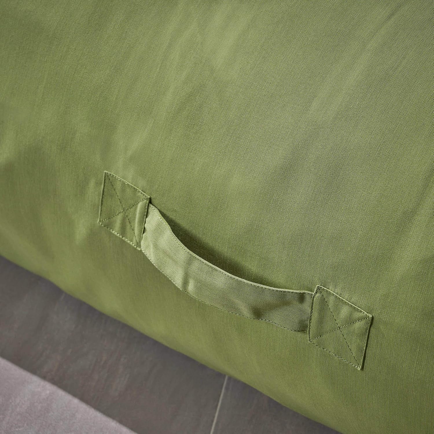 Close-up of a single stitched carry handle on olive-green lounger fabric.