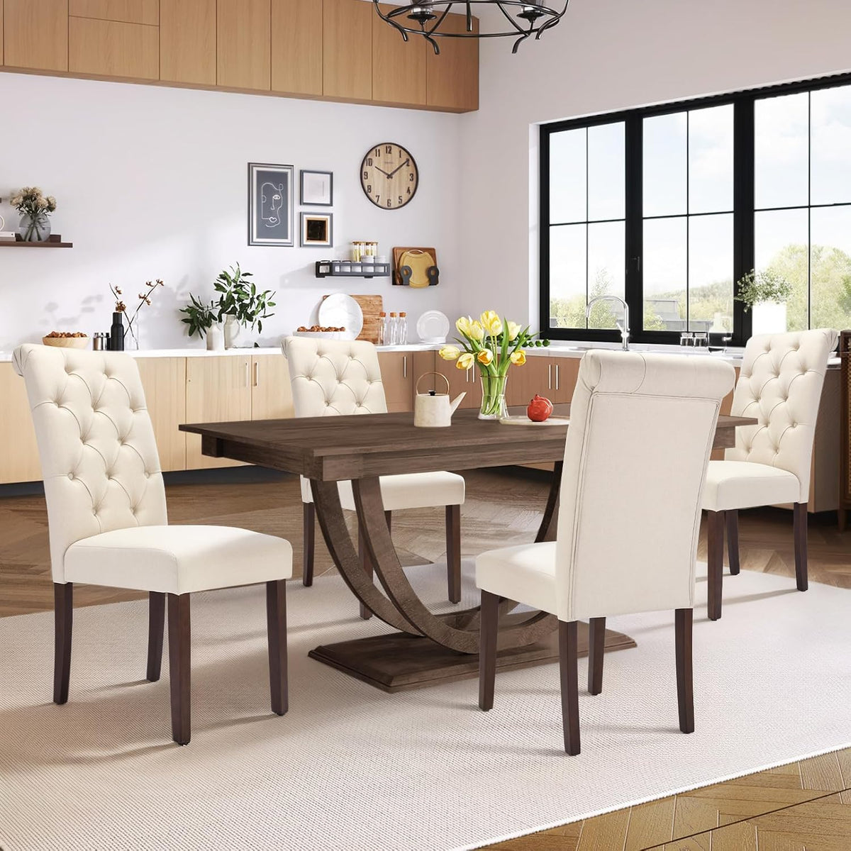 Rectangular wood dining table set with four light taupe tufted chairs and a vase of yellow tulips.