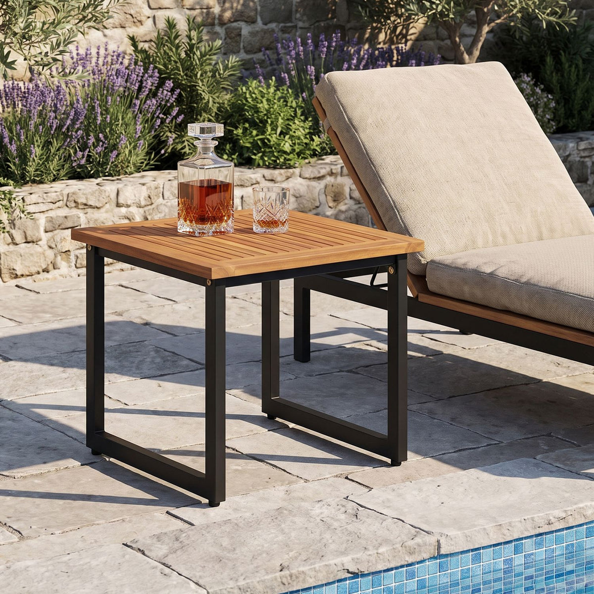Slatted wood side table beside a cushioned patio lounge chair, with glasses on the tabletop.