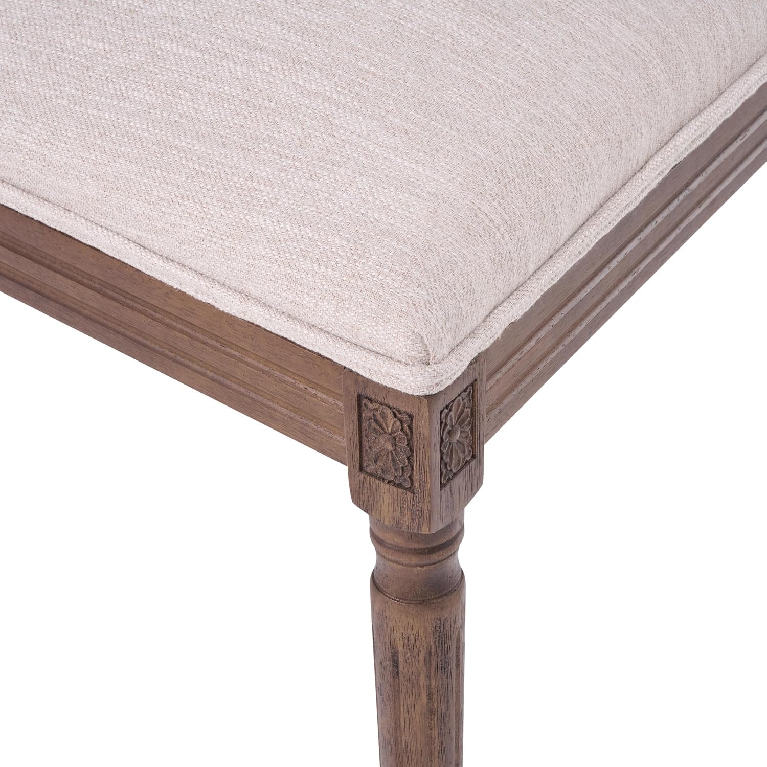 Close detail of a carved corner block, turned walnut leg and the beige seat seam
