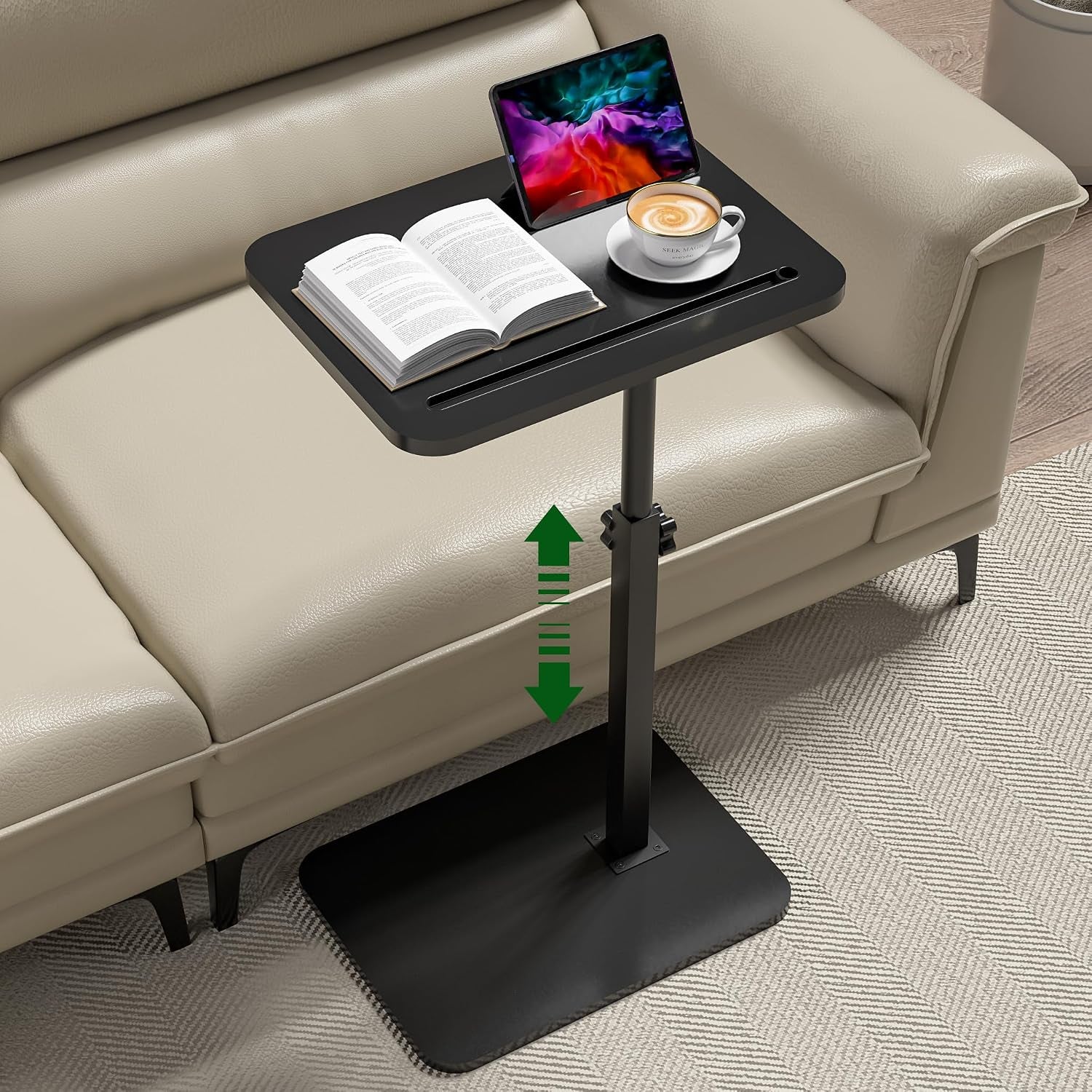 Black finish C-table beside a beige sofa with a book, tablet in the slot and a cup on the tabletop, arrow indicating