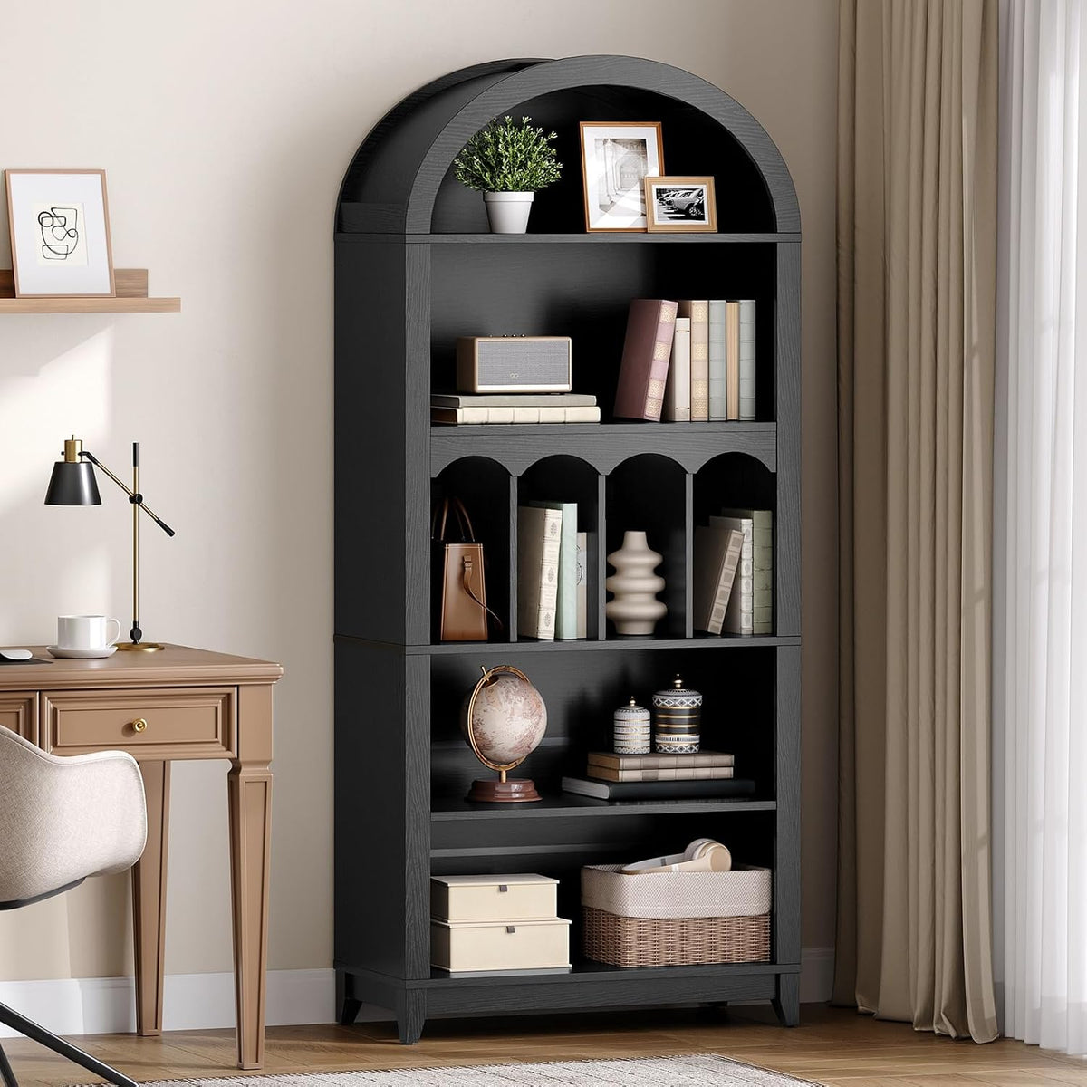 Close-up of the bookcase upper shelves with arch top showing books and framed photos next to a desk