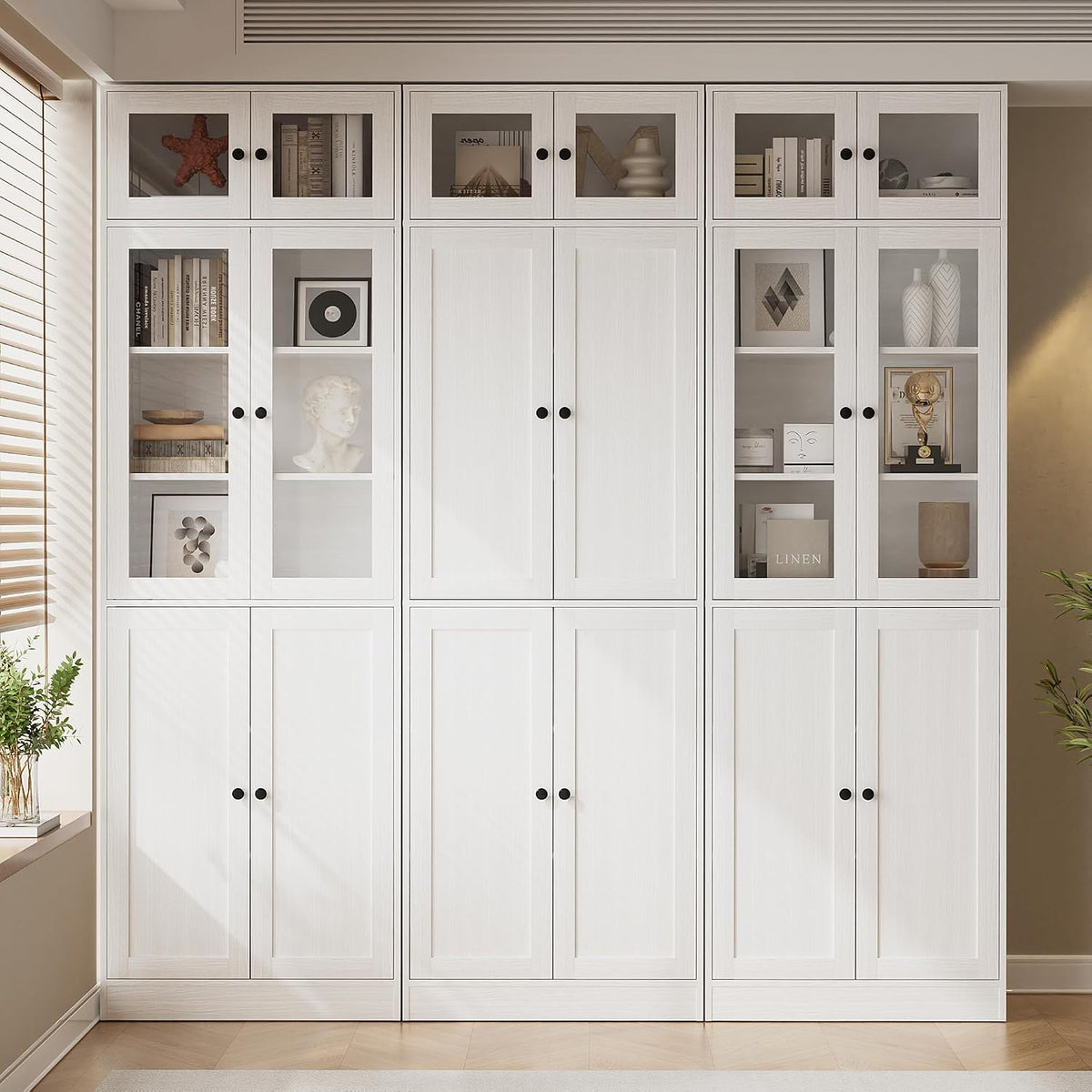 Tall white 7-tier bookcase wall with upper glass-front cabinets displaying decor and lower closed doors.