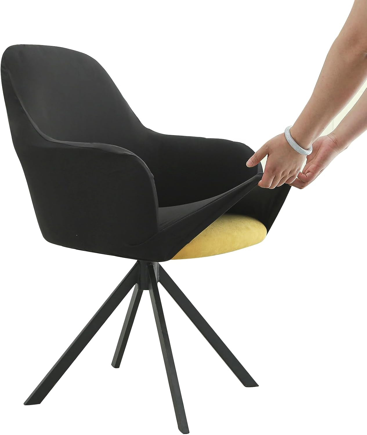 Side view of a black chair cover being stretched over a yellow seat by a pair of hands on a tripod-base chair.
