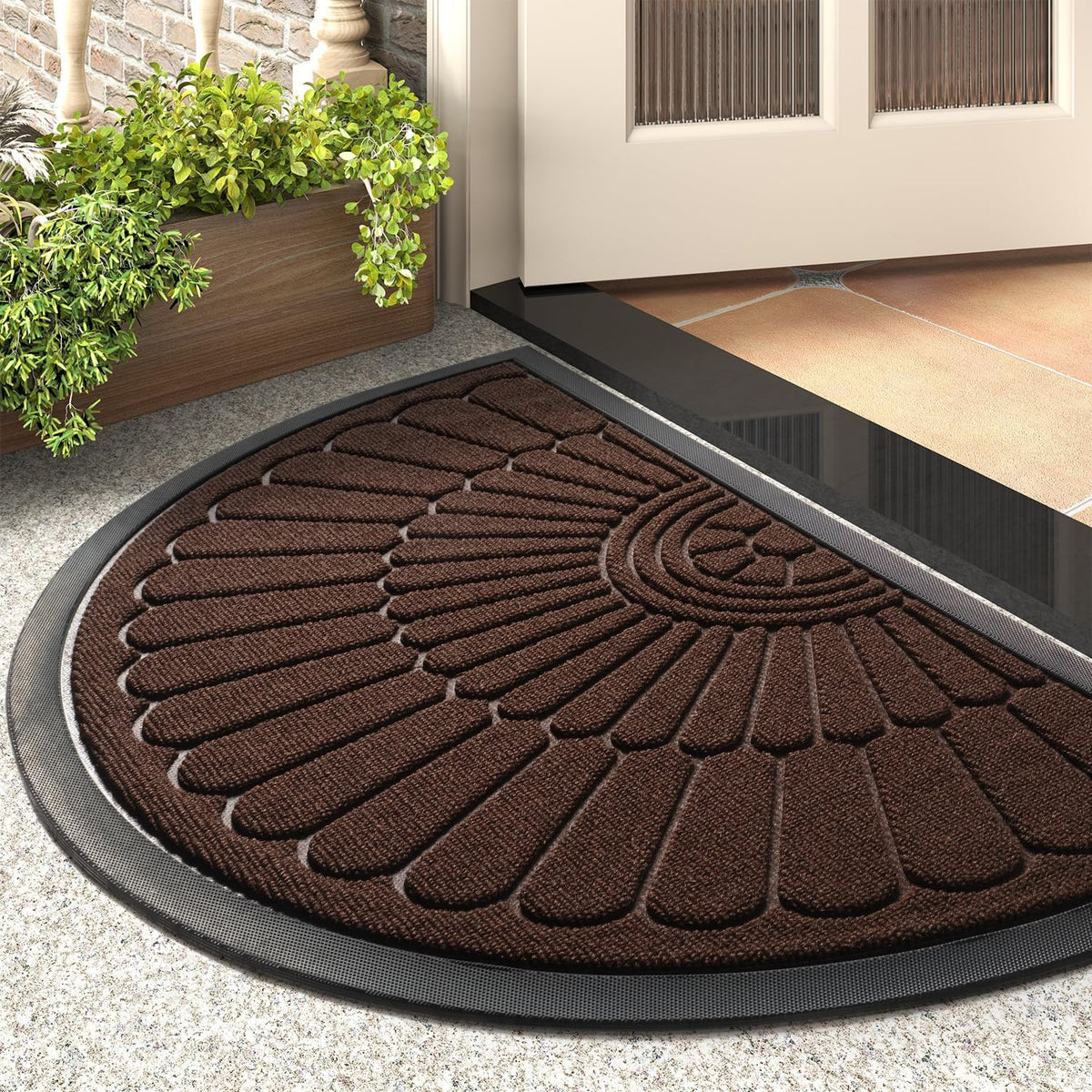 Dark brown semicircular mat placed by a front step beside a wooden planter and open door