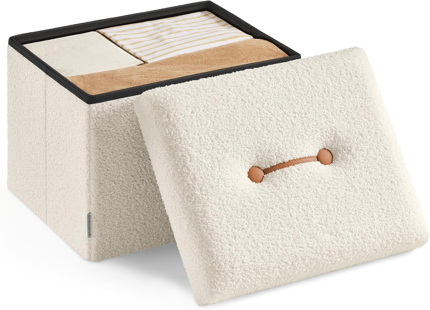 Cream-colored sherpa-texture ottoman with lid removed showing folded towels inside