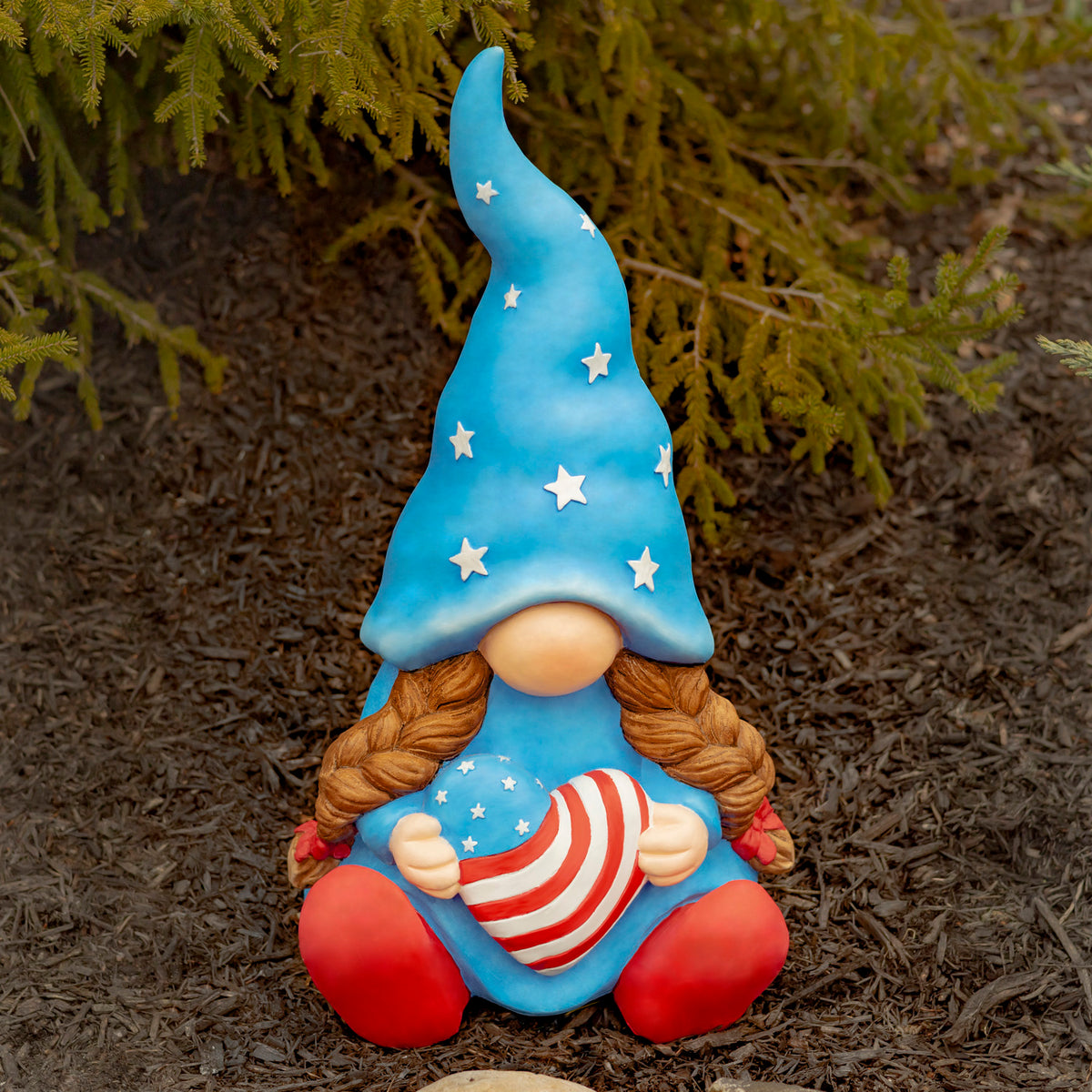 A seated garden gnome with a tall blue starry hat holds a red-and-white striped flag.