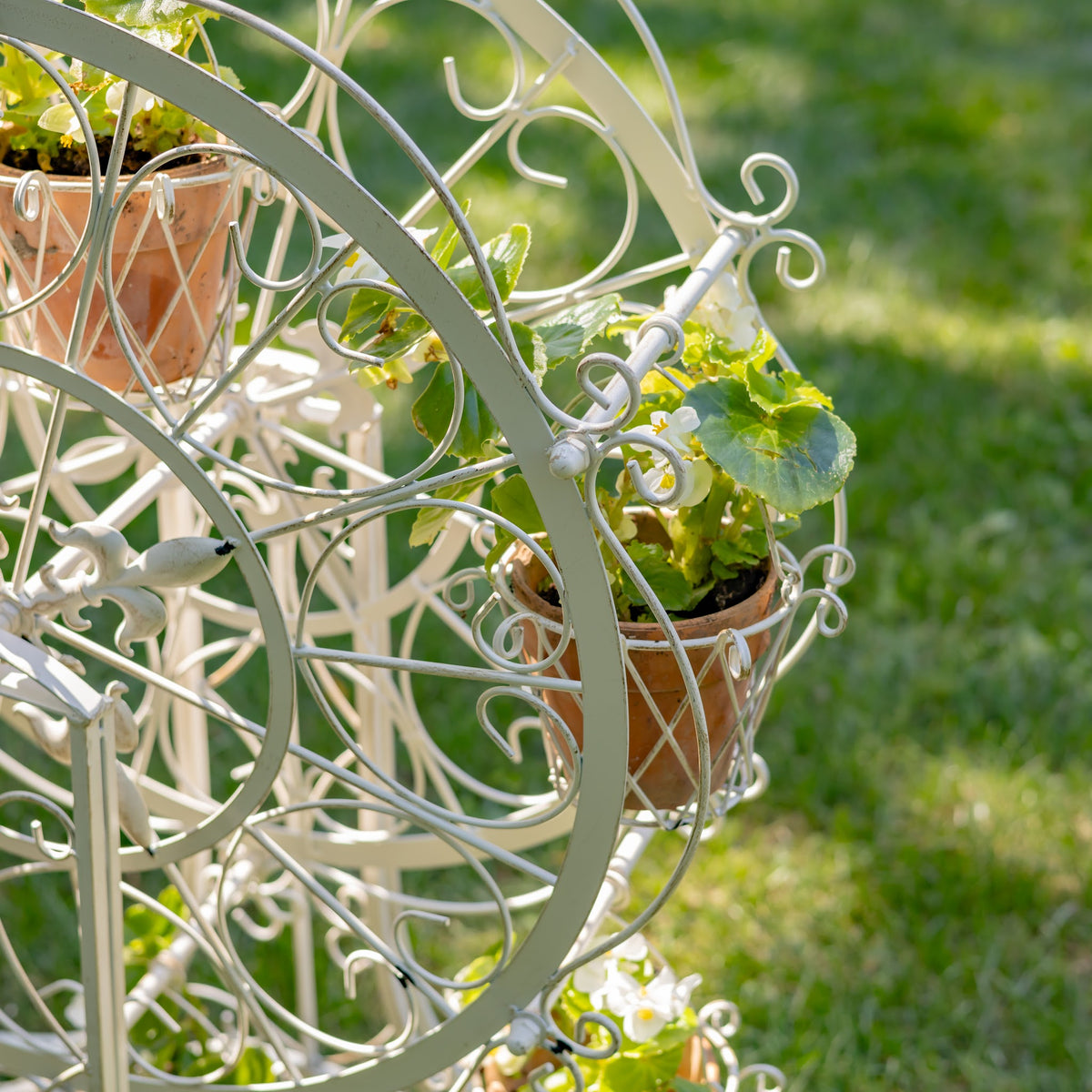 Close-up of a flower-filled basket hanging from the wheel frame
