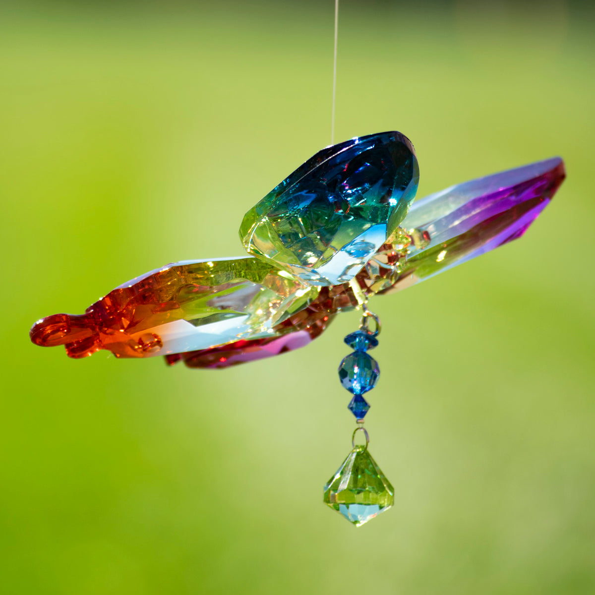 Close-up of a multicolored faceted butterfly ornament with dangling blue and clear beads.