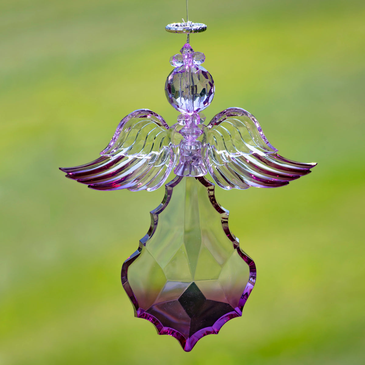 Purple angel ornament with broad wings spread horizontally against a green background.
