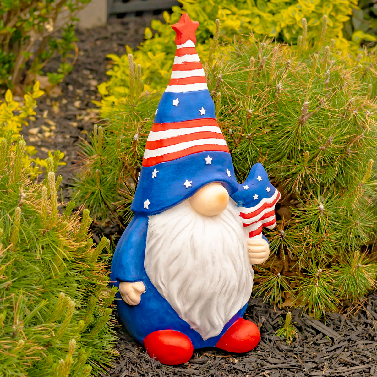 Garden gnome with a long white beard, red shoes, and a star-spangled hat holds a matching ornament.