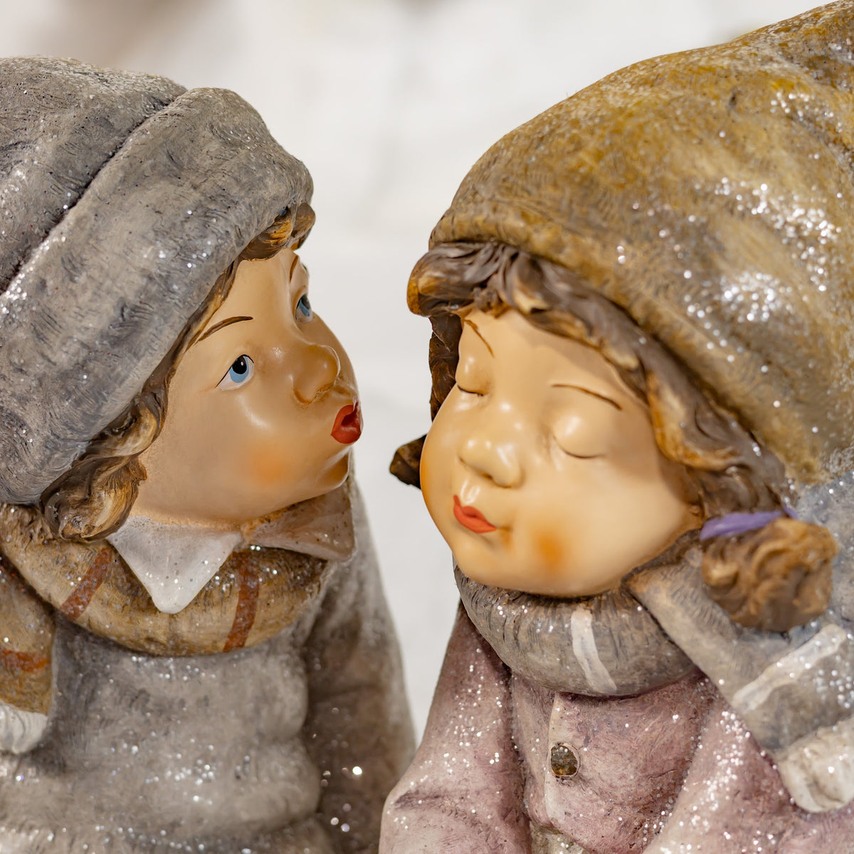 Close-up of the two figures facing each other, with one leaning toward the other's face.
