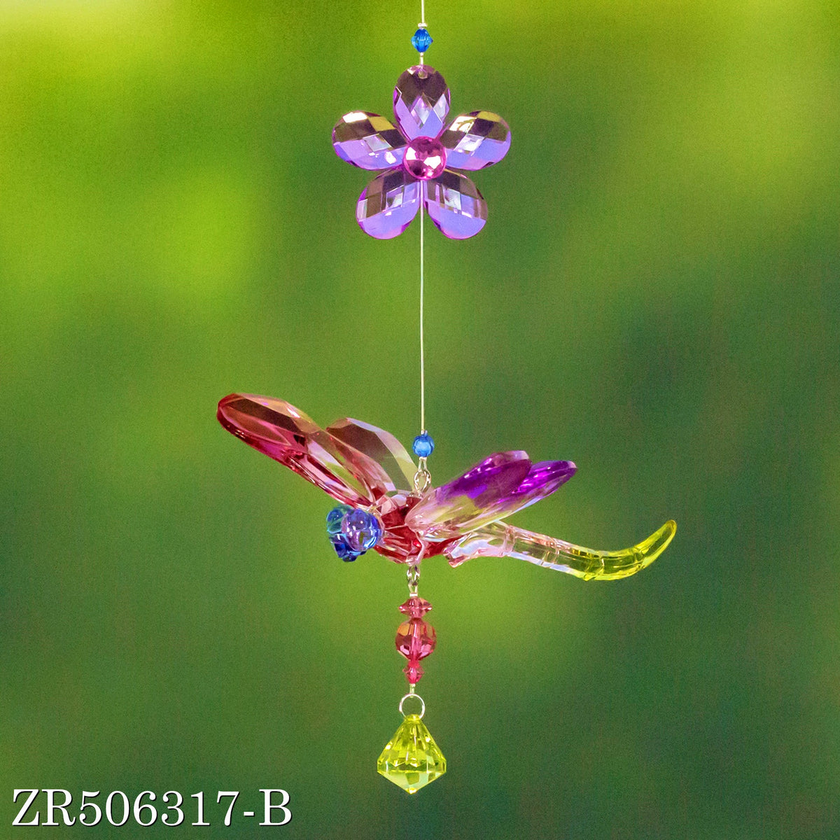 Purple and pink dragonfly ornament with a violet flower and bright green dangling crystal.