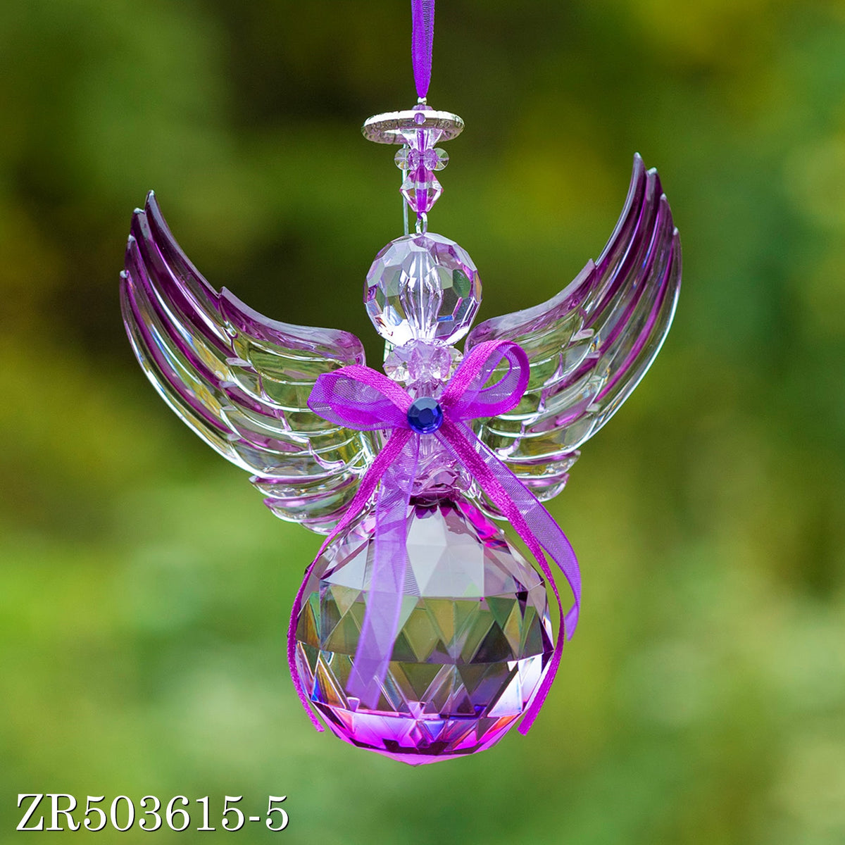 Close view of a purple acrylic angel ornament with spread wings, a blue-centered bow, and a hanging ribbon.
