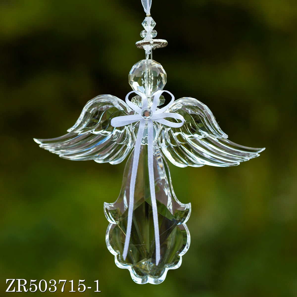 A clear angel ornament hangs against a green background, its broad wings spread around a white ribbon bow.
