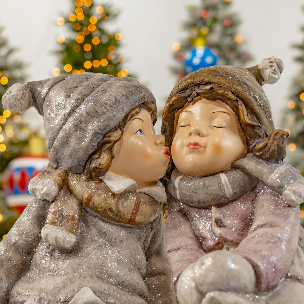 Close view of the gray-clad figure kissing the cheek of the figure in pink.