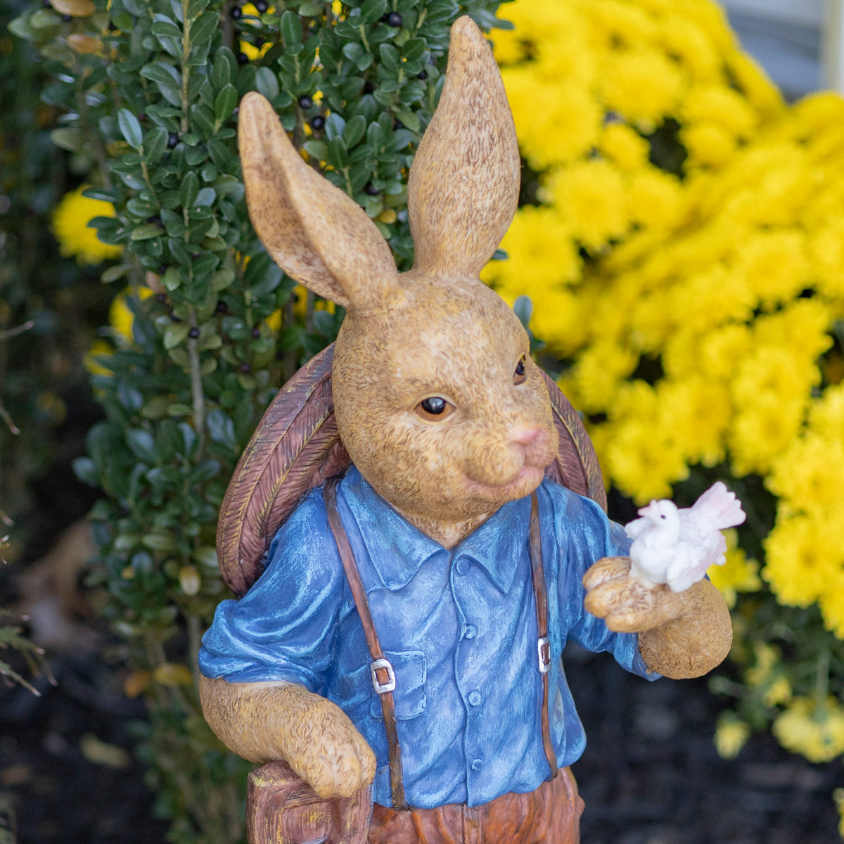 Close view of the rabbit's face, blue shirt, backpack straps, and white bird perched on its paw.
