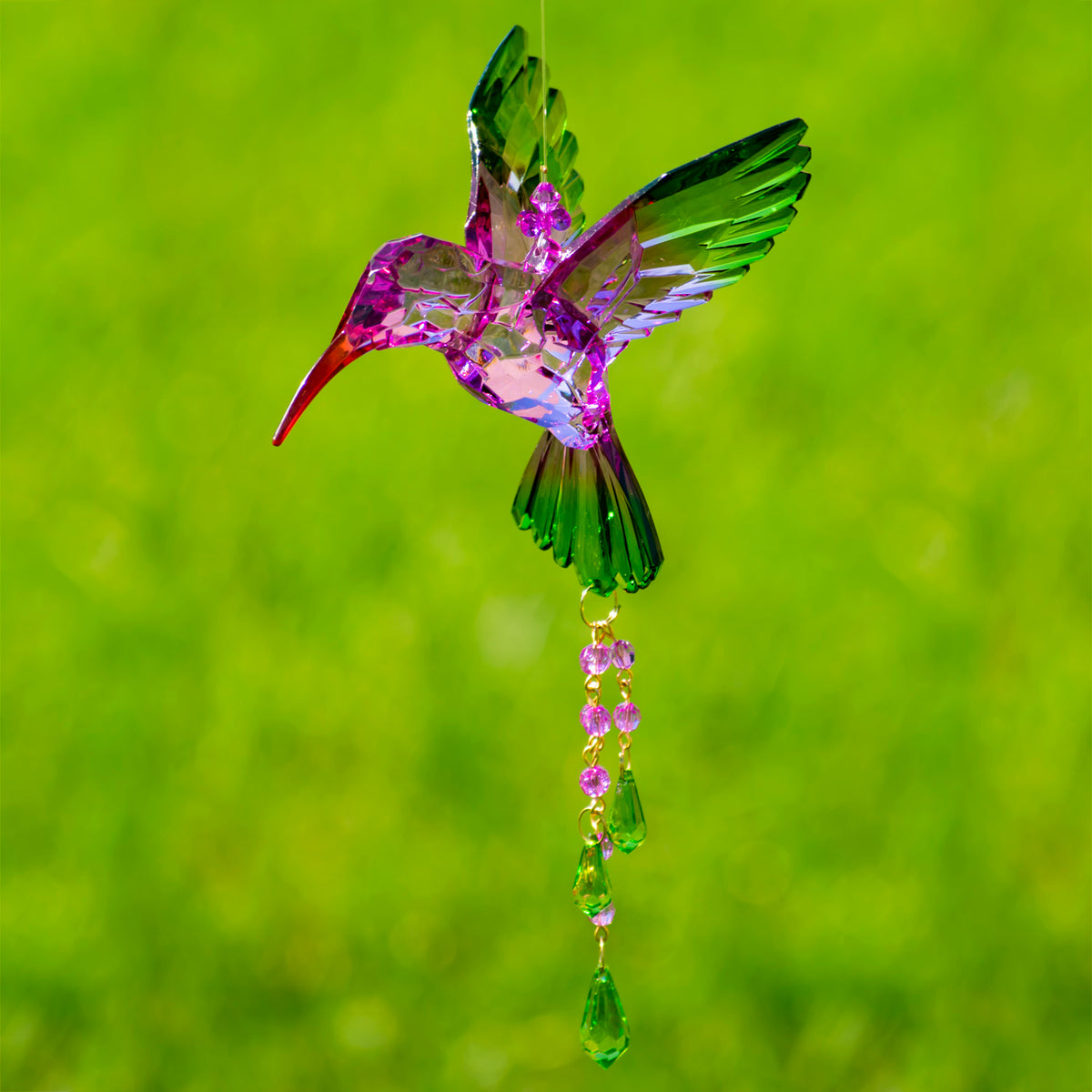 Pink and purple faceted hummingbird ornament with green wings and a strand of colorful beads.