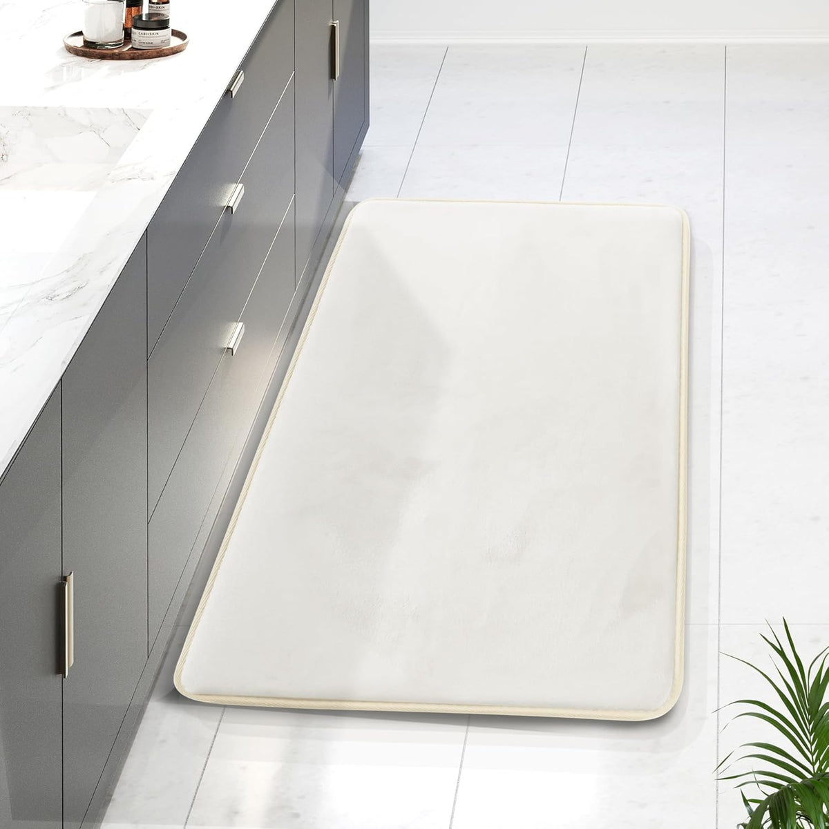 Overhead view of a long cream runner mat placed alongside a grey vanity on a bright tiled bathroom floor.