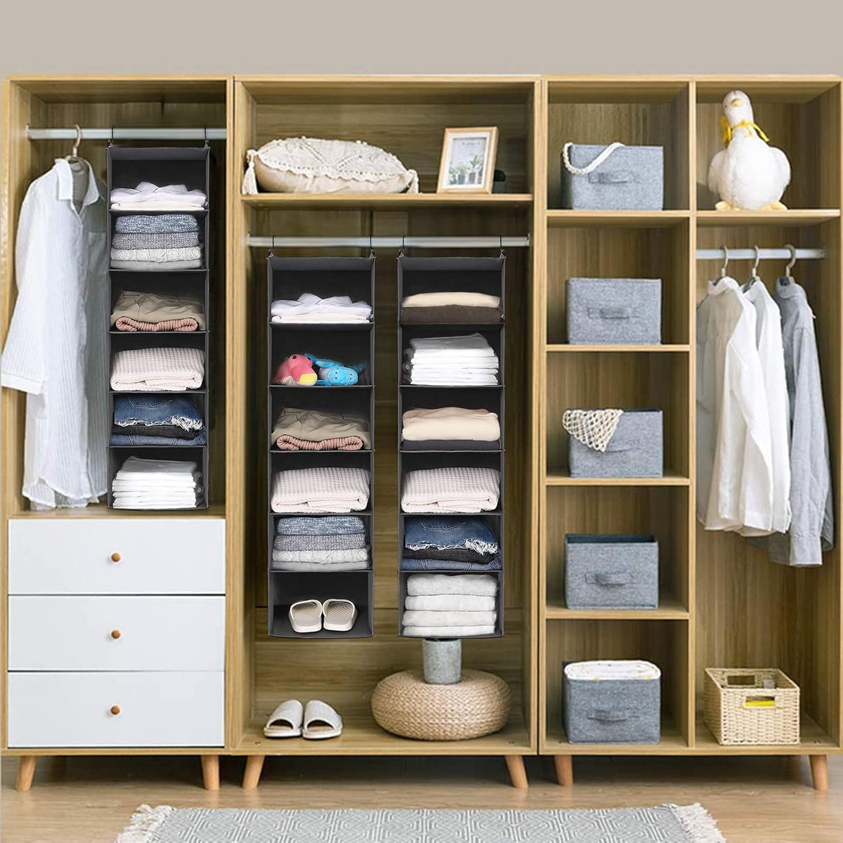 Three grey hanging organizers installed inside a wood-paneled closet holding folded clothes, toys and shoes.