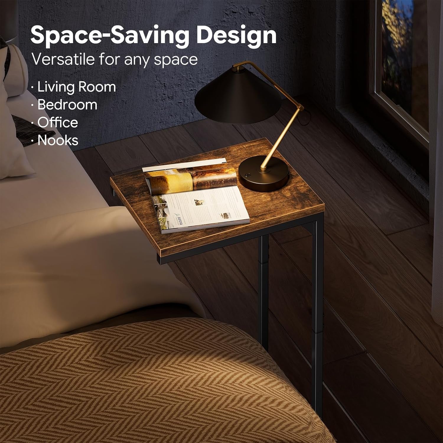 Bedroom view of a small C-shaped side table tucked beside a bed holding a lamp and open magazine.