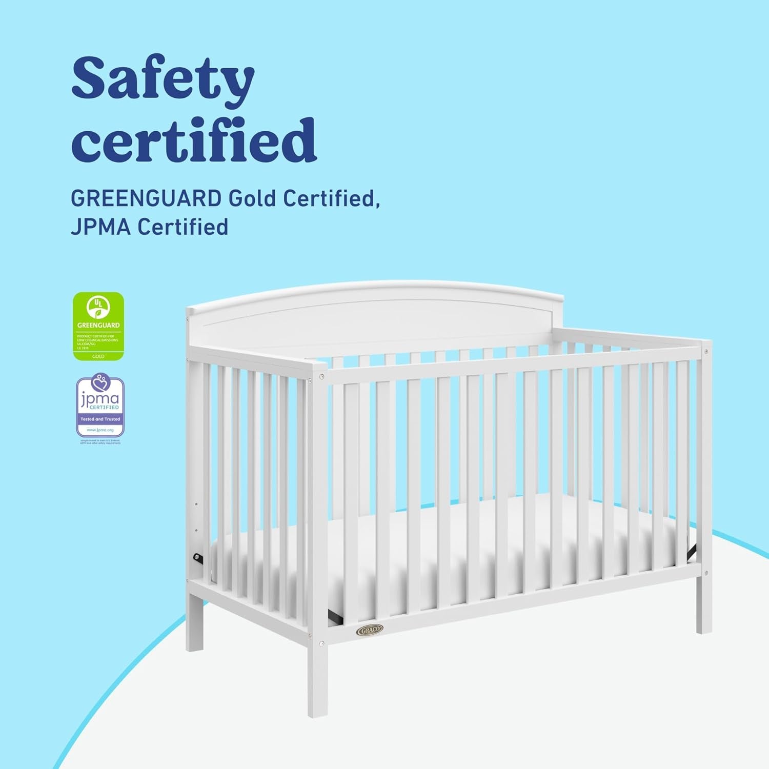 Three-quarter view of a white convertible crib on a light blue background with certification badges to the left.