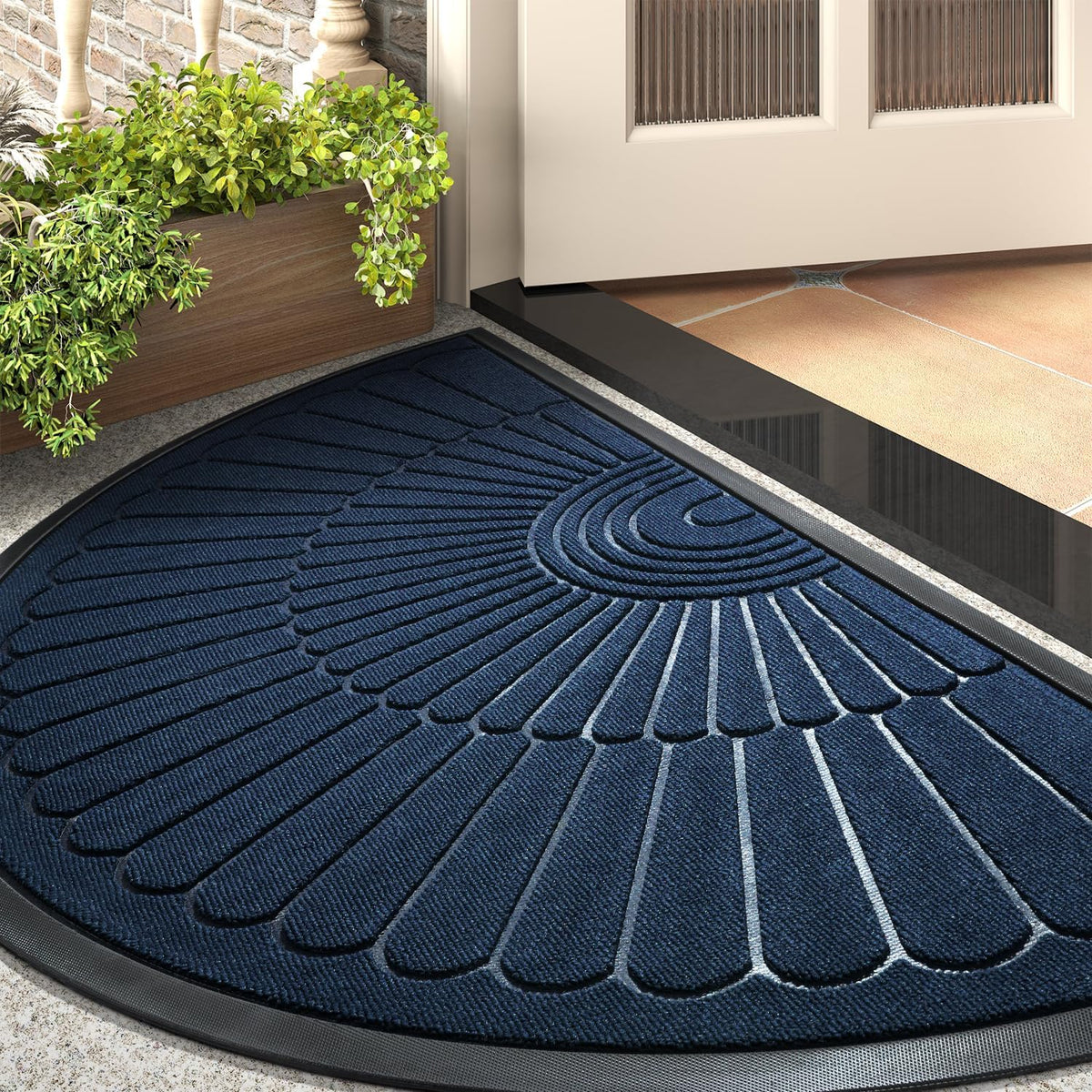 Navy blue semicircular mat near a tiled threshold with planter visible at the edge