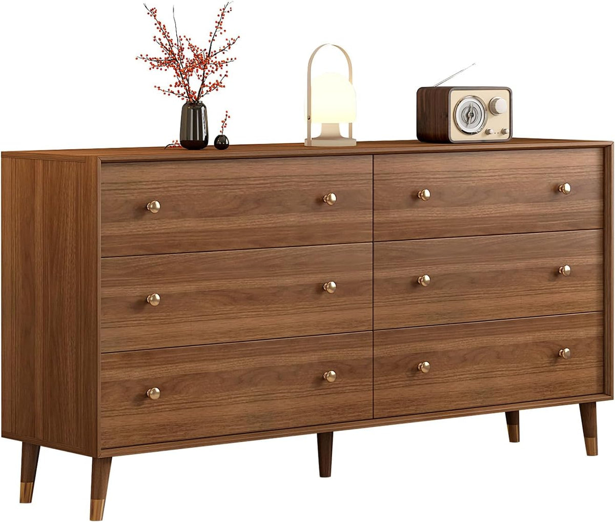 Straight front view of a brown six-drawer dresser with round electroplated knobs and tabletop decor.