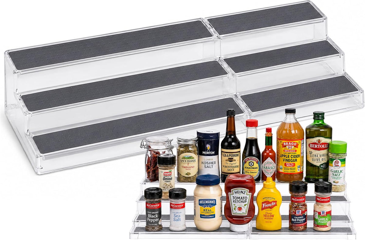 Angled product shot of two clear 3-tier racks joined end-to-end with grey non-slip pads; condiments lined on front tier.