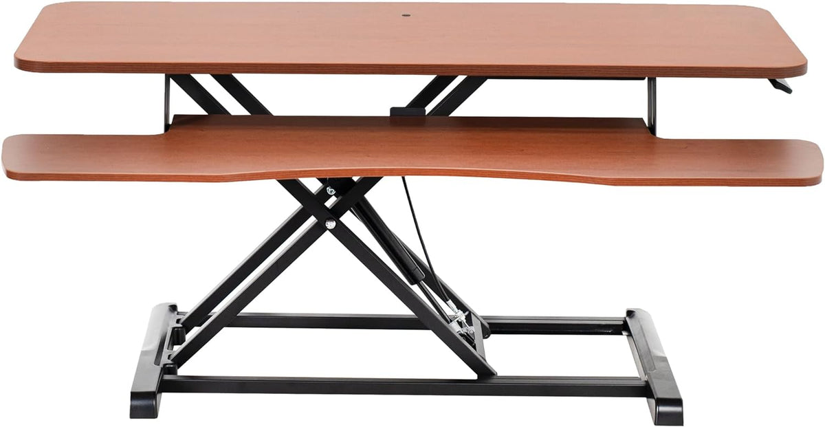 Front view of a two-tier wooden standing desk converter with black metal X-frame and cherry finish tops.