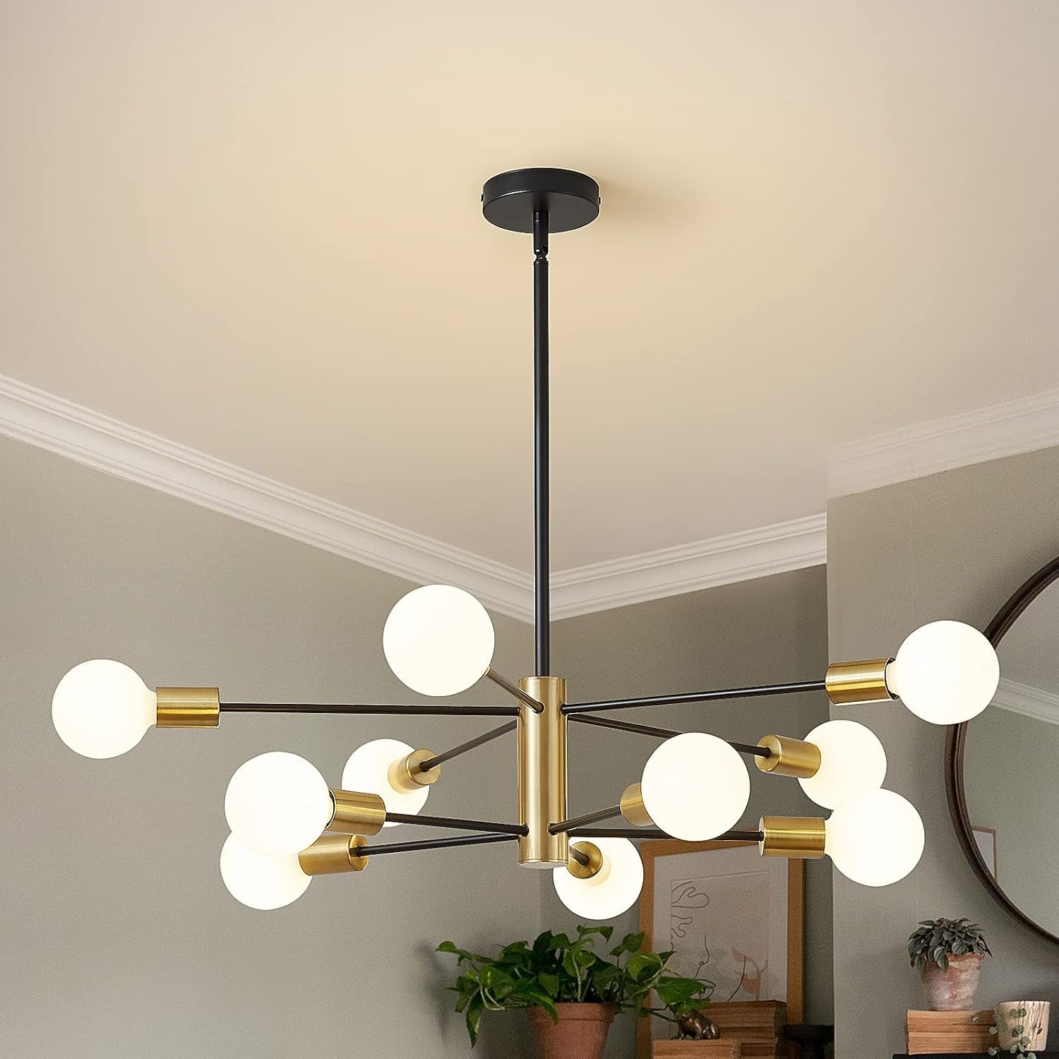 Black-and-gold sputnik chandelier with multiple glowing globe bulbs over a living area.