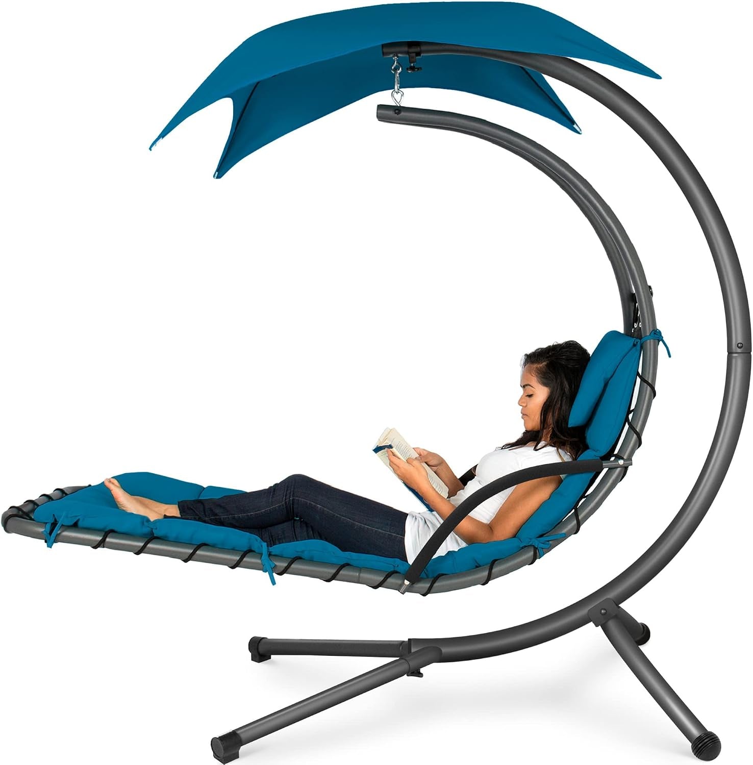 Curved hanging chaise with teal cushions and dark gray frame, woman reclines reading beneath teal canopy.