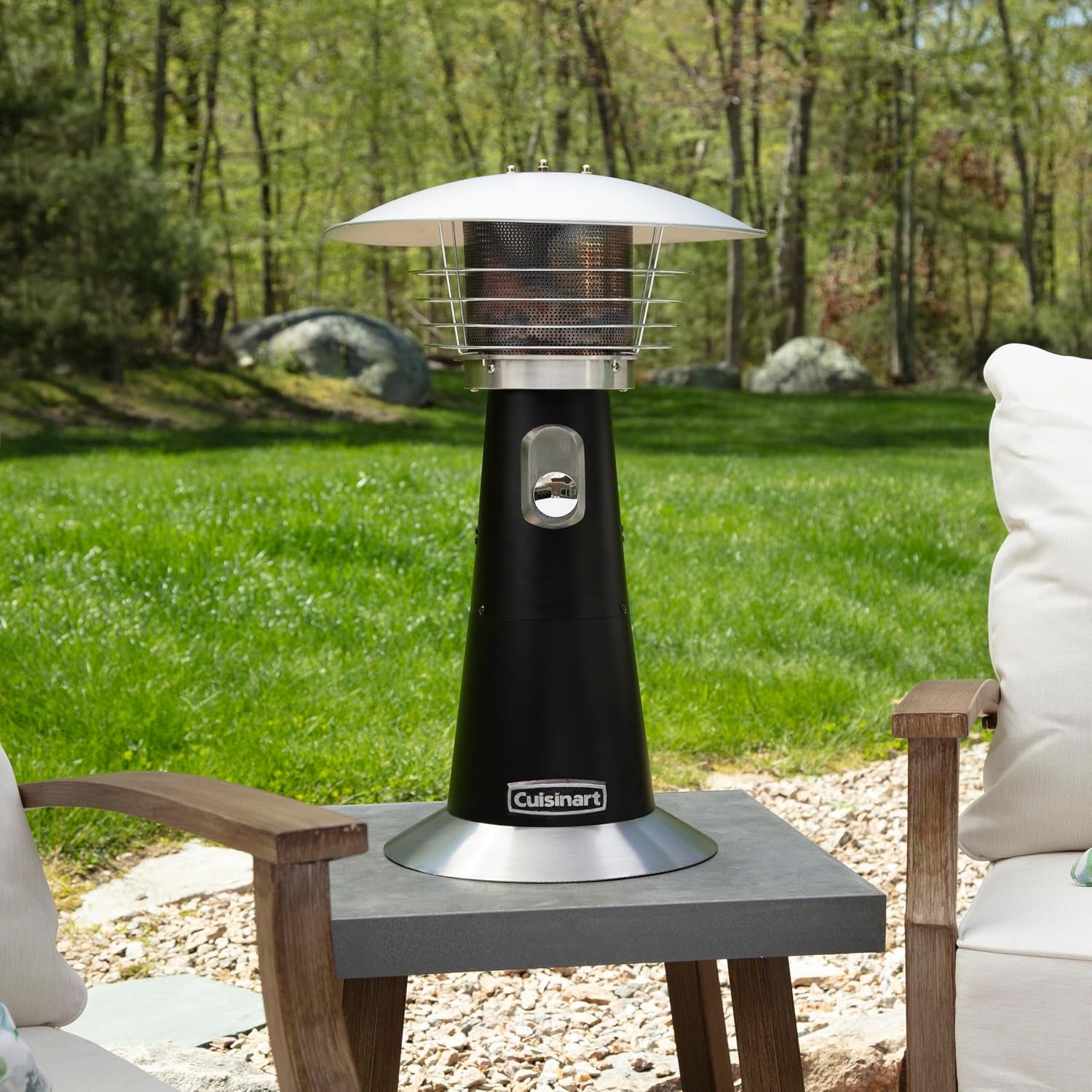 Straight-on view of the black tabletop patio heater sitting on a small outdoor table between cushioned chairs.
