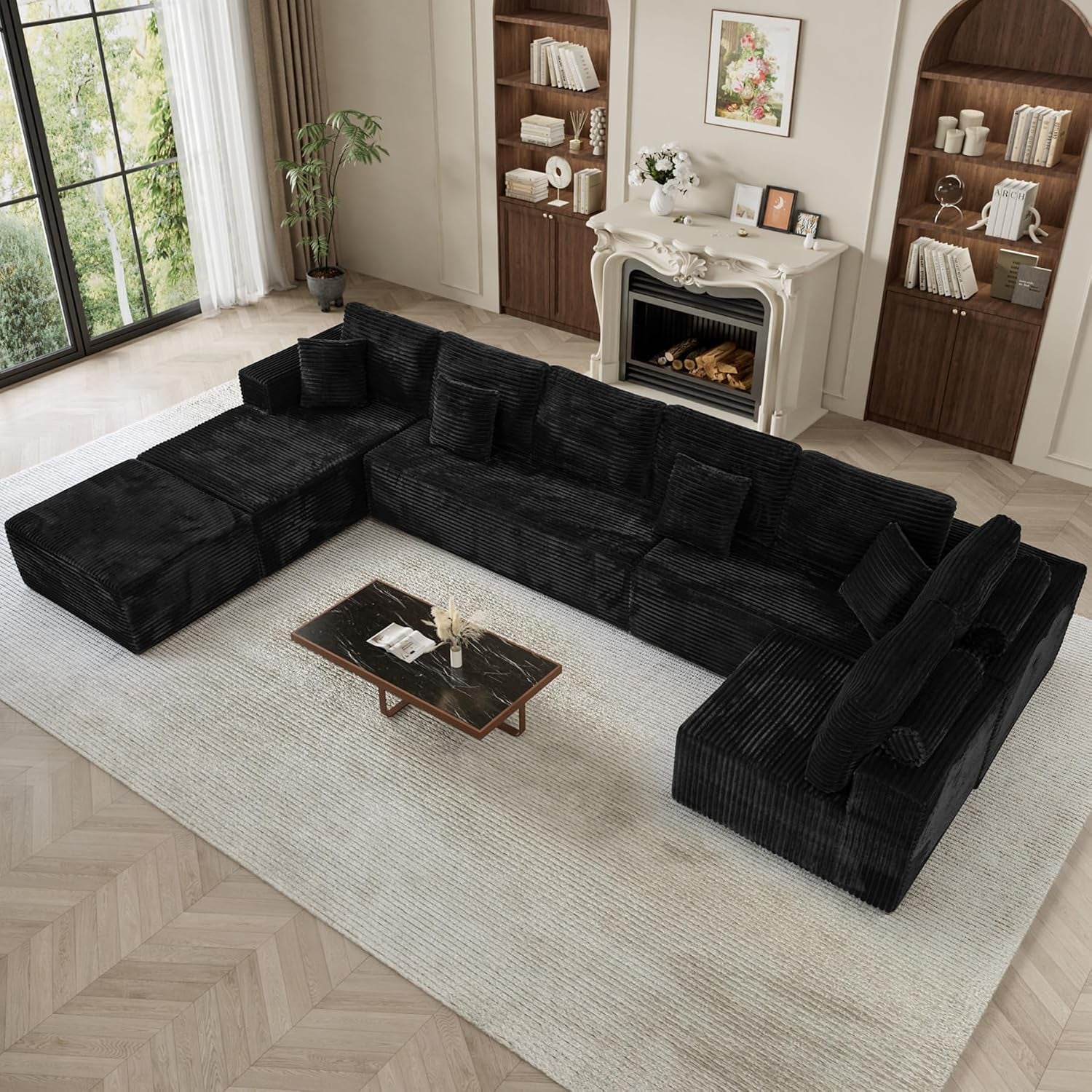 Top-down view of a black L-shaped modular sectional with chaise arranged around a low coffee table