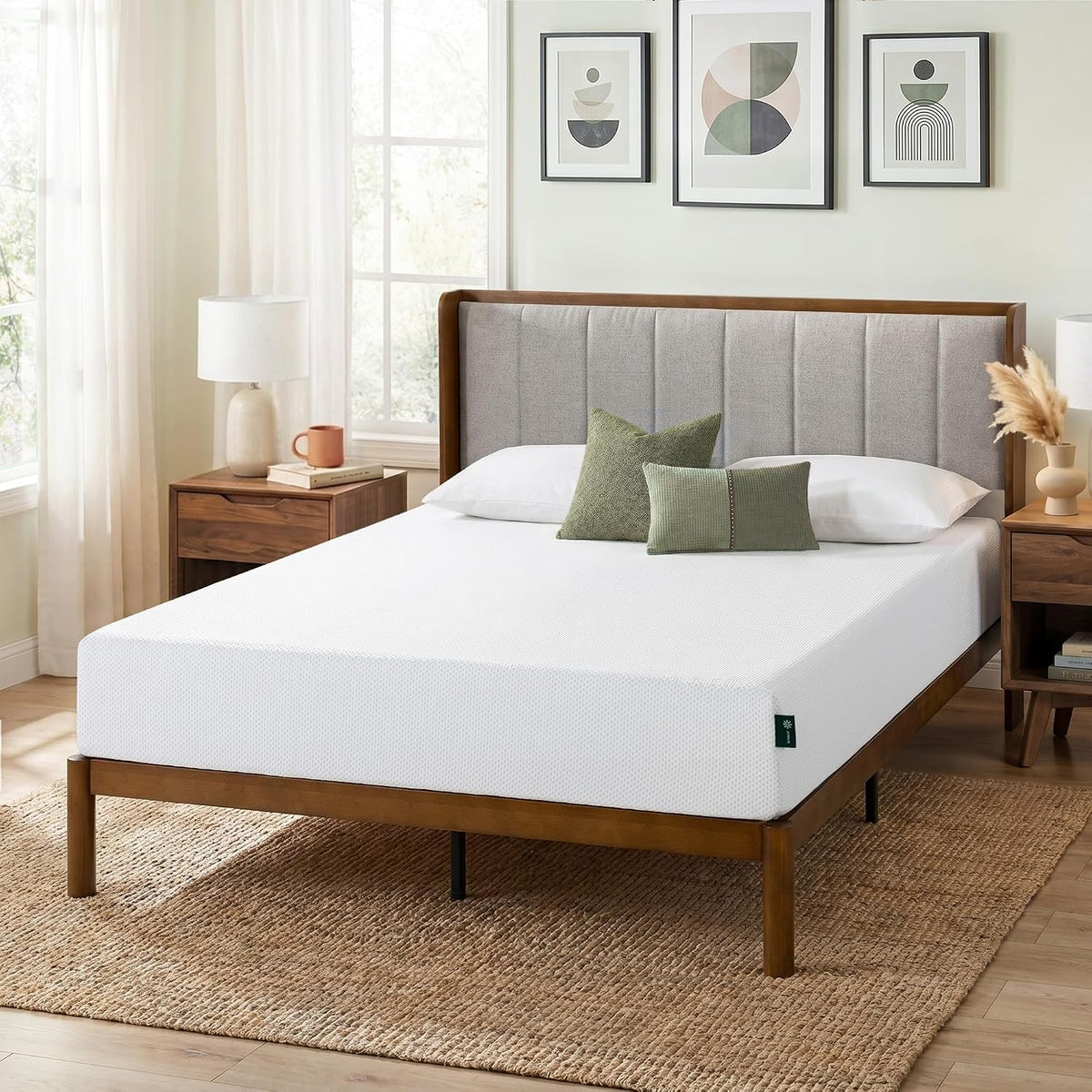 White mattress on a wooden frame with pillows and bedside tables in a softly lit bedroom