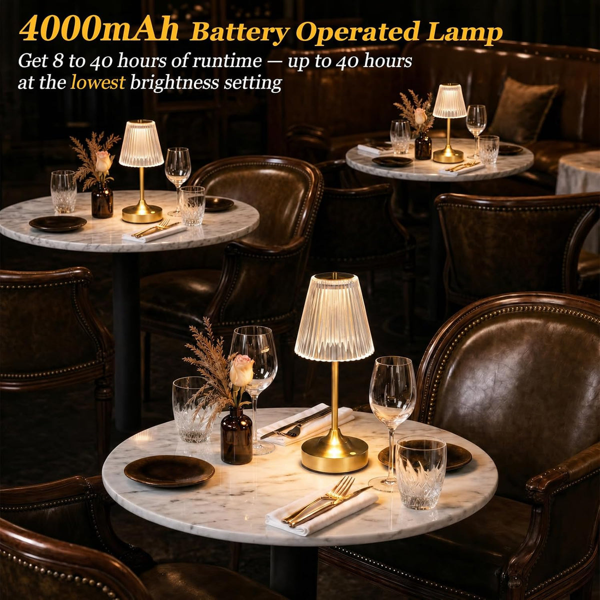 Gold cordless table lamp lit on a marble restaurant table setting with place settings and ambient lighting