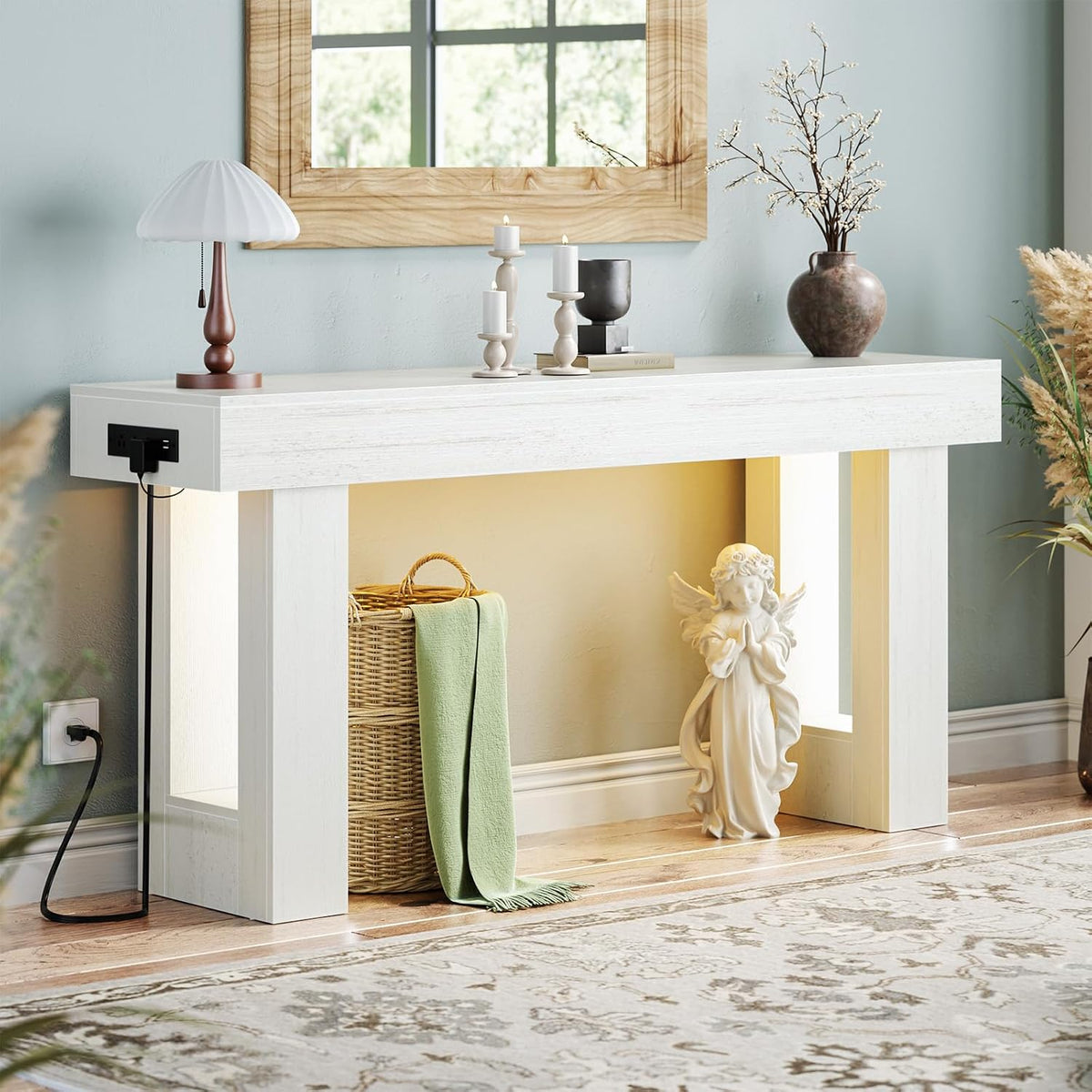 Front view of the console in white finish with an angel statue tucked under the warm-lit shelf.