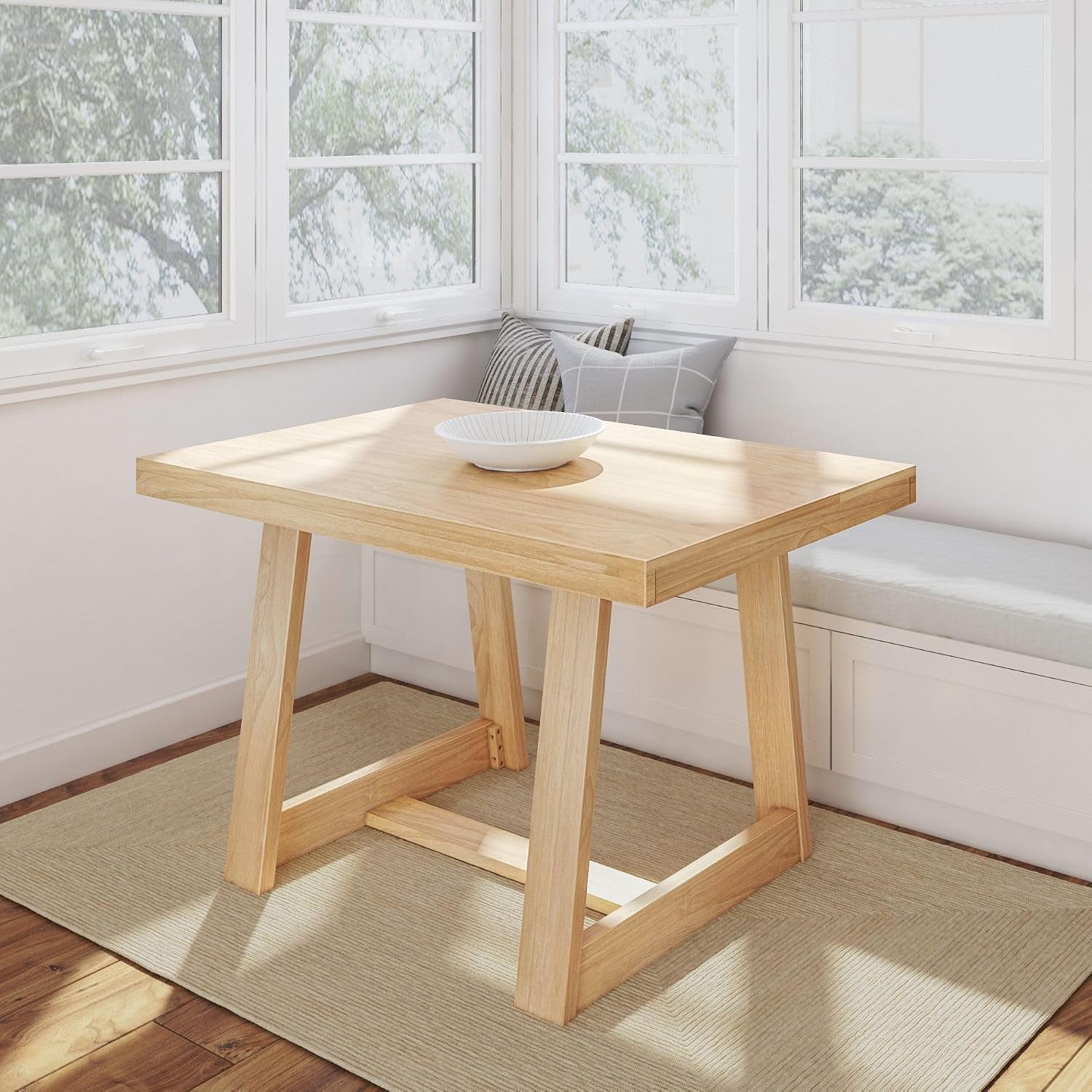 Light pecan-finish rectangular pine table in a sunlit window nook with a bowl on top