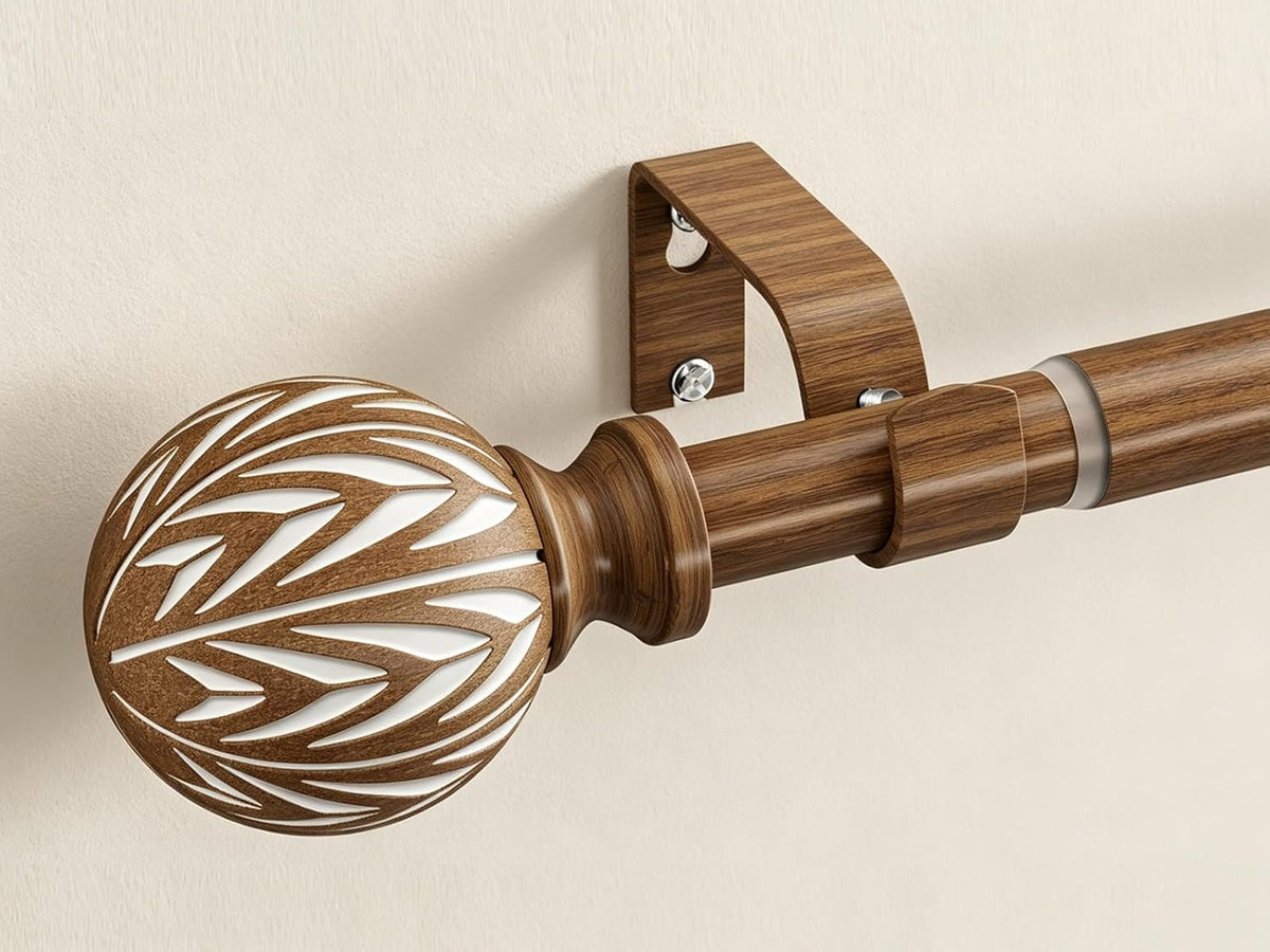 Side view of wood-grain rod showing a carved spherical finial with white cutout pattern and telescoping collar.