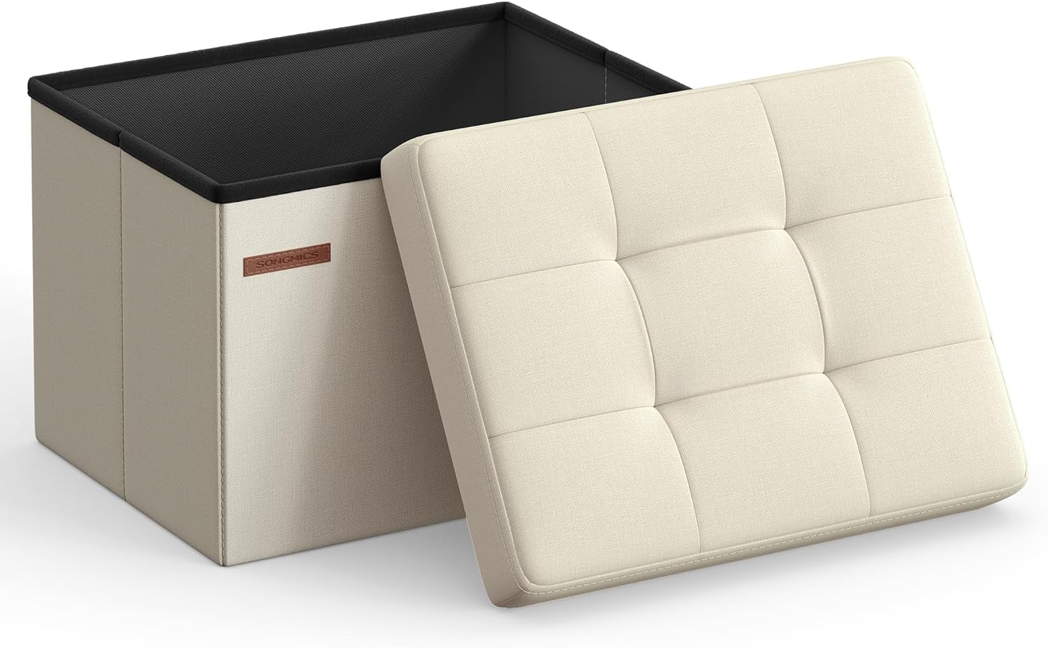 Three-quarter view of a light cream fabric folding storage ottoman with the tufted lid leaning against the open box