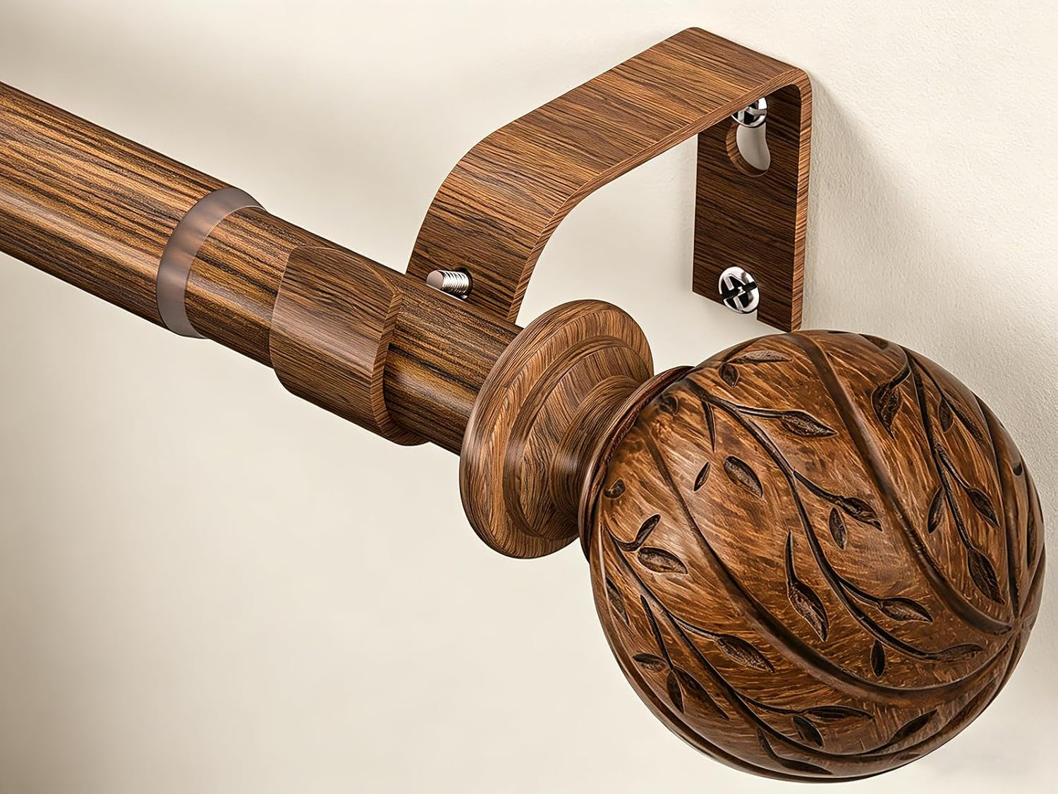 Wood-grain curtain rod close-up showing carved leaf-vine round finial and matching mounting bracket on a beige wall.