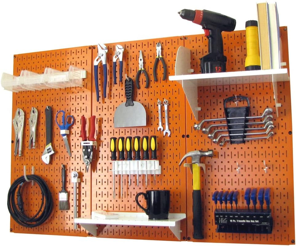 Orange metal pegboard wall with assorted hand tools, shelves, and hooks arranged across it.