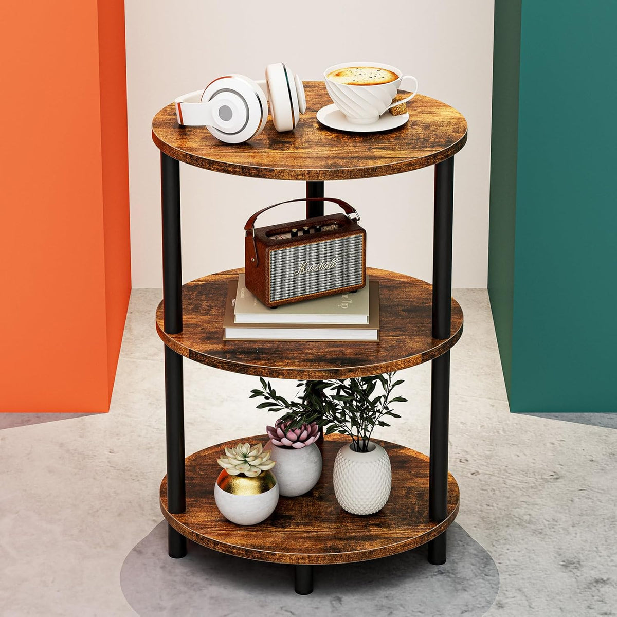 Three-tier round side table in rustic brown with headphones and cup on the top shelf and plants on the lower shelf