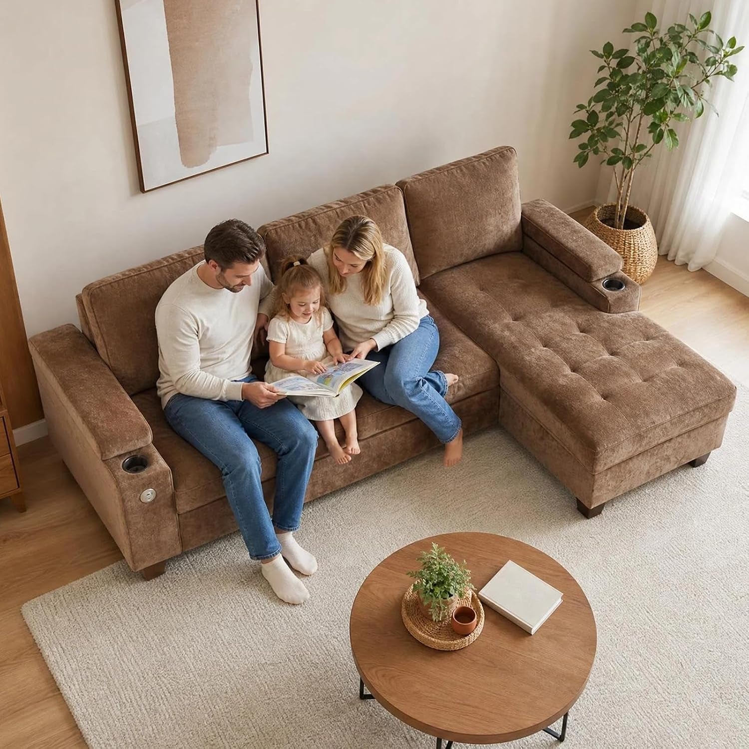 Overhead view of a brown sectional with a tufted chaise occupied by a family of three, cup holder visible in the arm.