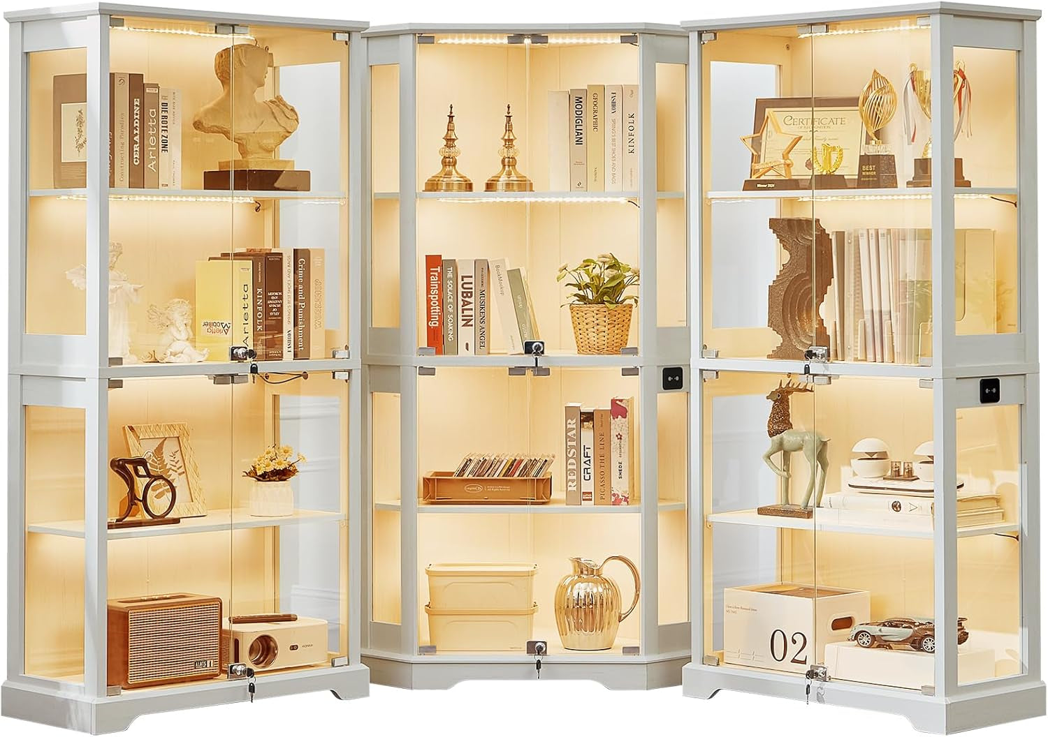 Three white glass display cabinets in a row, LED-lit with books, decor, and trophies on glass shelves.